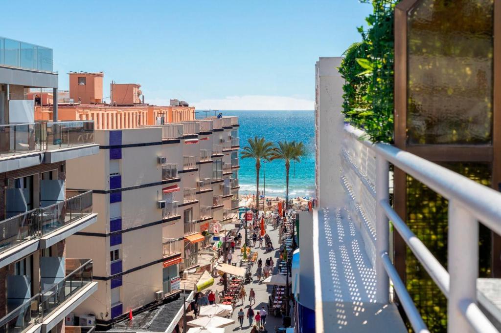 uma vista a partir de uma varanda de uma rua com edifícios e o oceano em Apartamentos Aurea em Benidorm