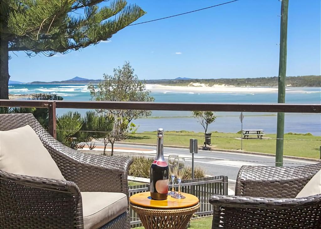a bottle of wine sitting on a table on a balcony at Peninsula in Sawtell