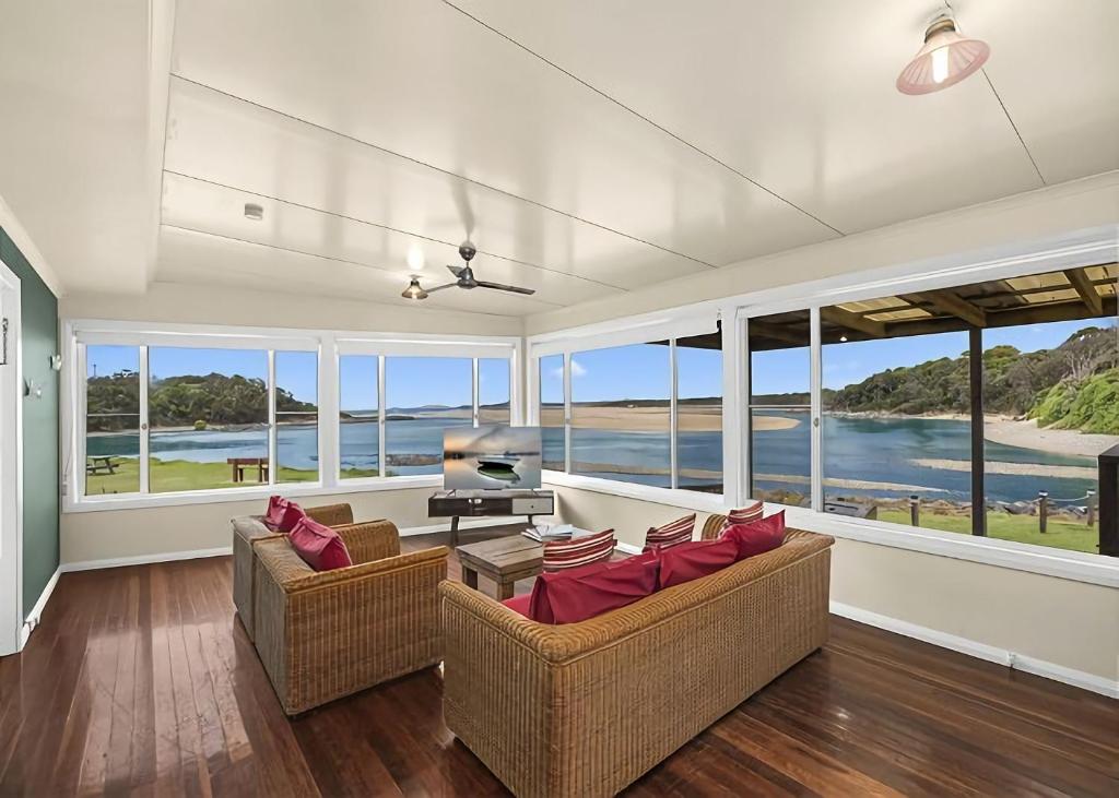 a living room with two couches and a tv at Lobster Cottage in Sawtell
