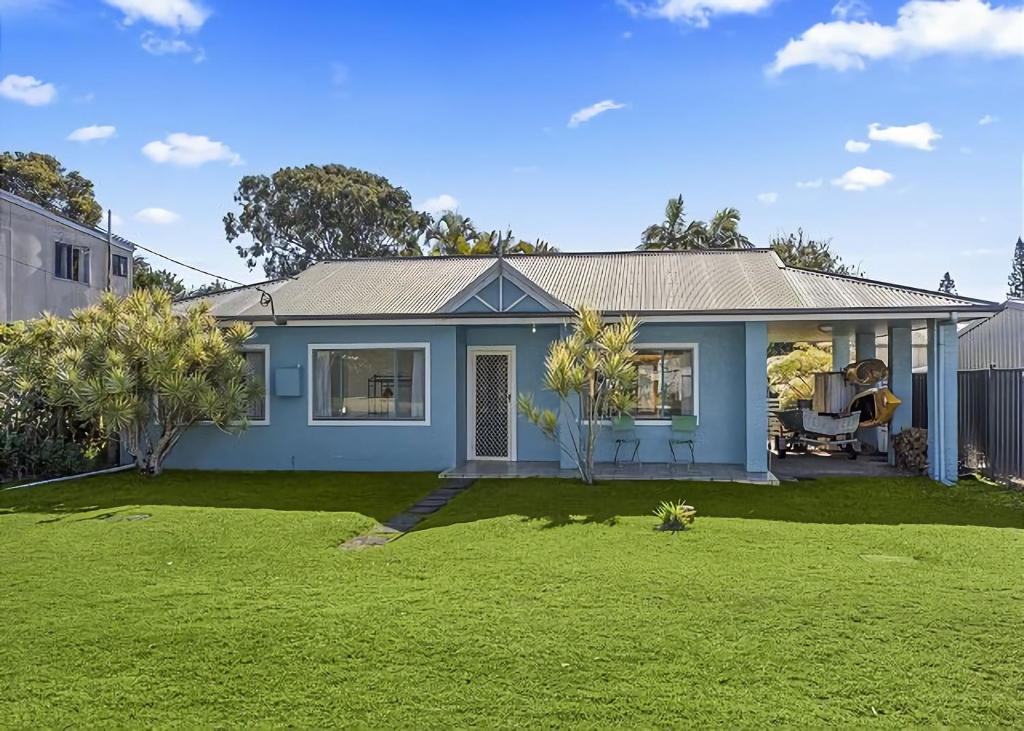 a blue house with a lawn in front of it at Ronnie s Cottage in Mylestom