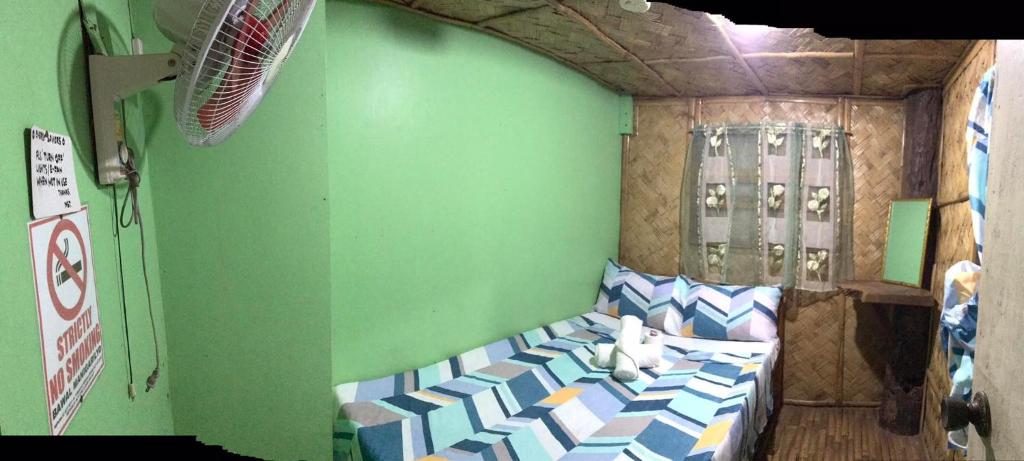 een slaapkamer met een bed in een groene muur bij Alexandra's Transient Haus in Donsol
