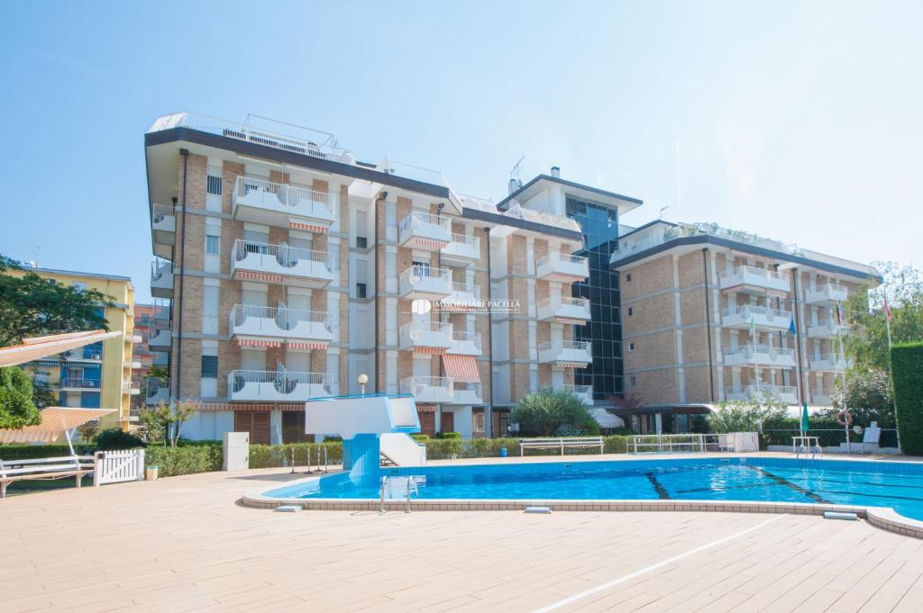 un complejo de apartamentos con piscina frente a un edificio en Residence Santa Fè Immobiliare Pacella, en Lido di Jesolo