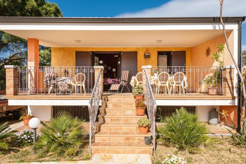 a home with a deck with chairs and tables at Villetta Bacio del Sole in Sìnnai
