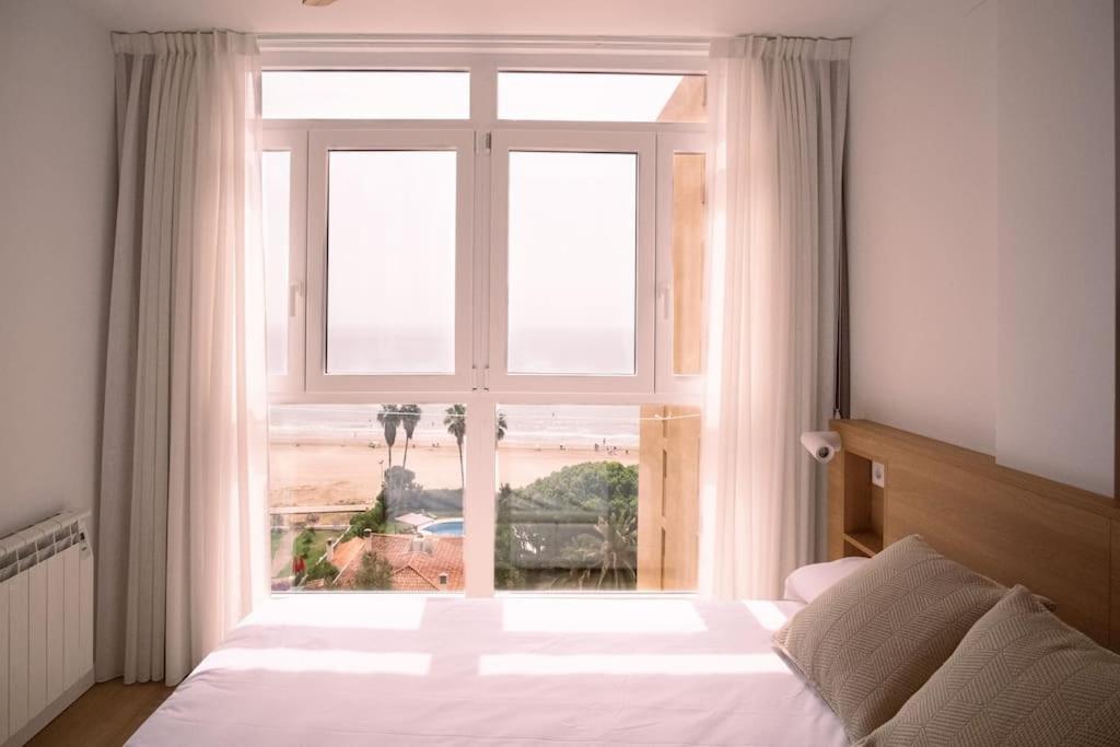 1 dormitorio con ventana grande con vistas a la playa en Spectacular renovated studio facing the sea, en Valencia