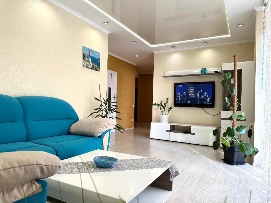 a living room with a blue couch and a tv at Lux apartments in the city center, near the park and Zlata Plaza in Rivne