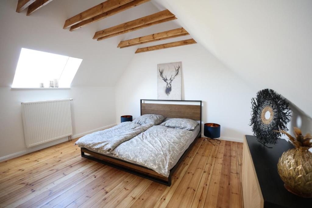 Schlafzimmer mit einem Bett und Holzboden in der Unterkunft Travetraum in Lübeck