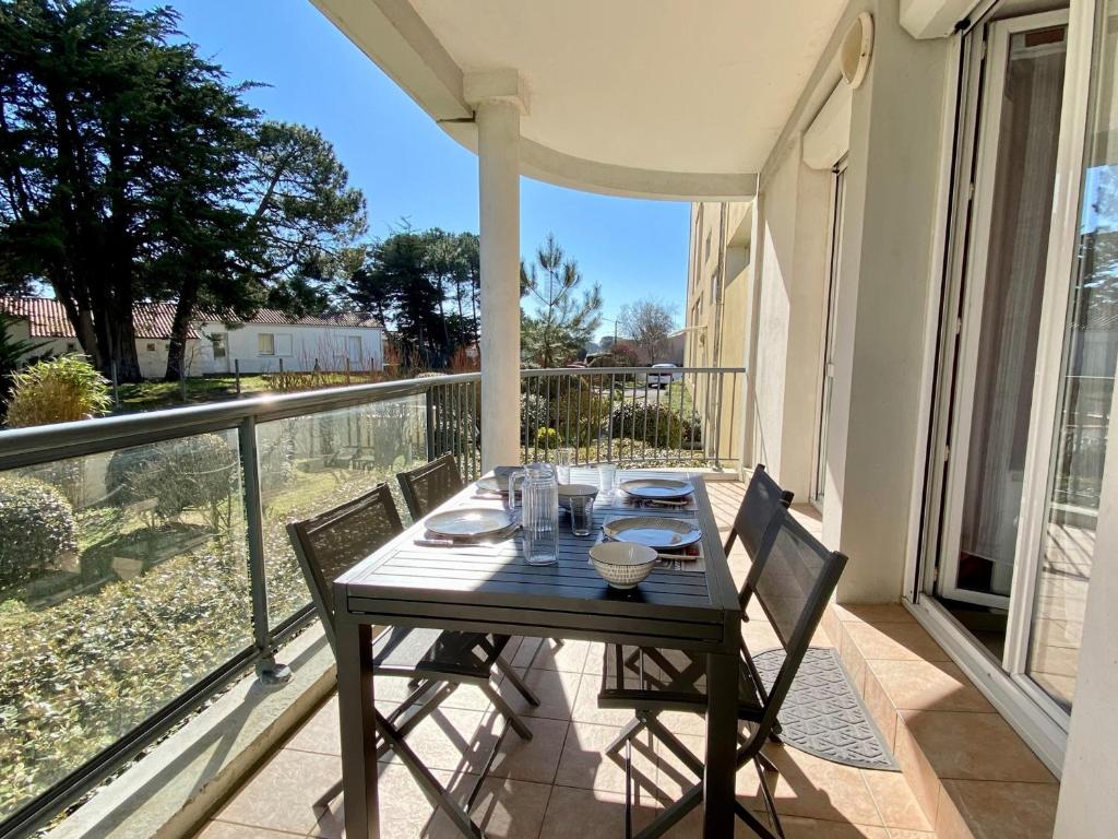 une table et des chaises sur le balcon d'une maison dans l'établissement Appartement 2 pers. rénové avec balcon, accès plage et centre-ville à pied - Classé 2* - FR-1-231-285, à Bretignolles-sur-Mer