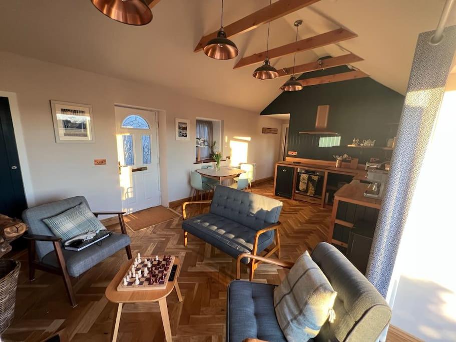 a living room with furniture and a chessboard on the floor at Osprey Hide in Forres