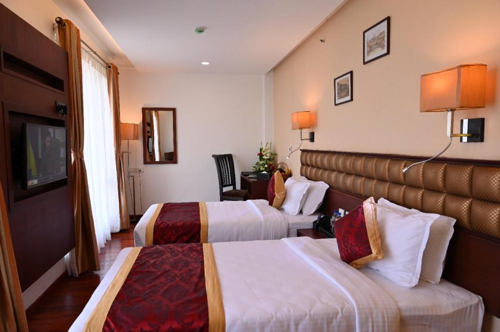 Postel nebo postele na pokoji v ubytování Raaj Bhaavan Clarks Inn Chennai