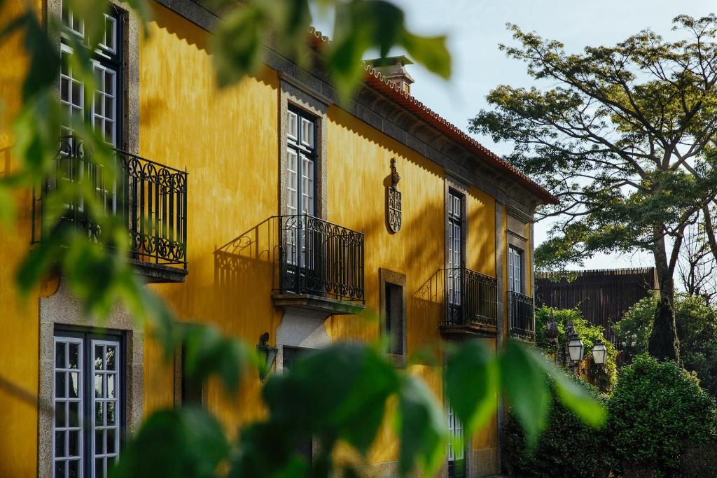 a yellow building with balconies and a clock on it at Quinta Da Bouca D'Arques in Vila de Punhe