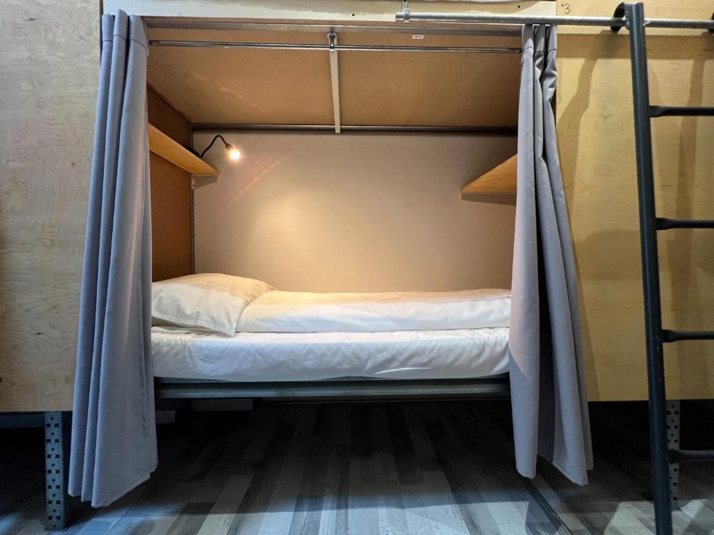 a bunk bed in a hostel room with a mosquito net at The Old Factory in Copenhagen