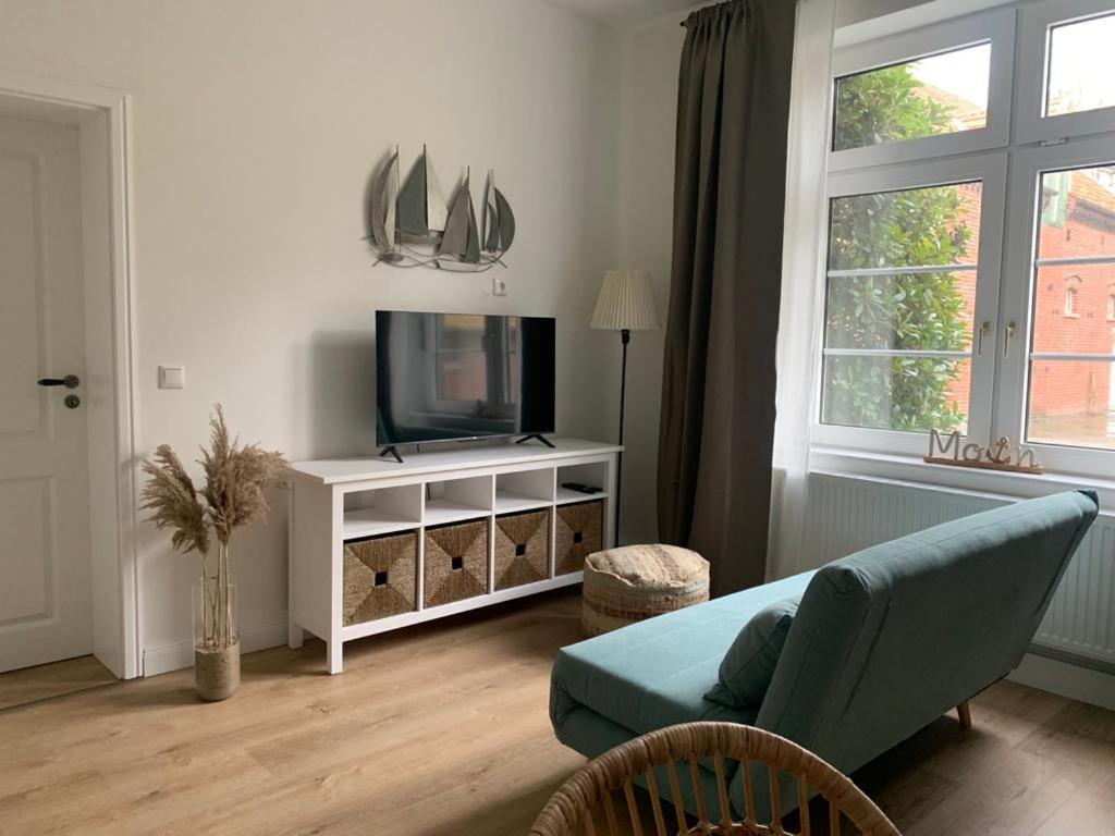 sala de estar con sofá y TV en NEU Küstenliebe Friesland, en Varel