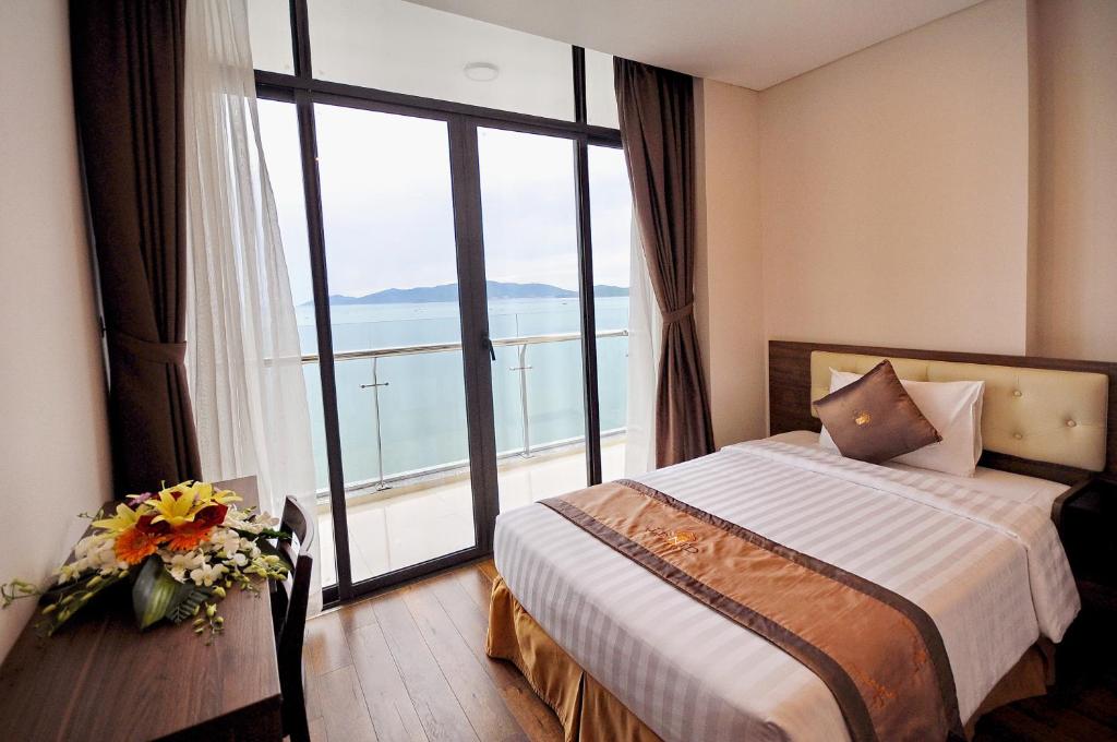 a hotel room with a bed and a large window at Lenid Ocean View Hotel in Nha Trang