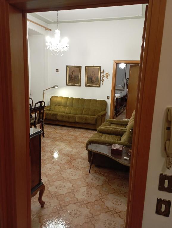 a living room with a green couch and a table at Casa San Carlo Affittacamere Foligno in Foligno