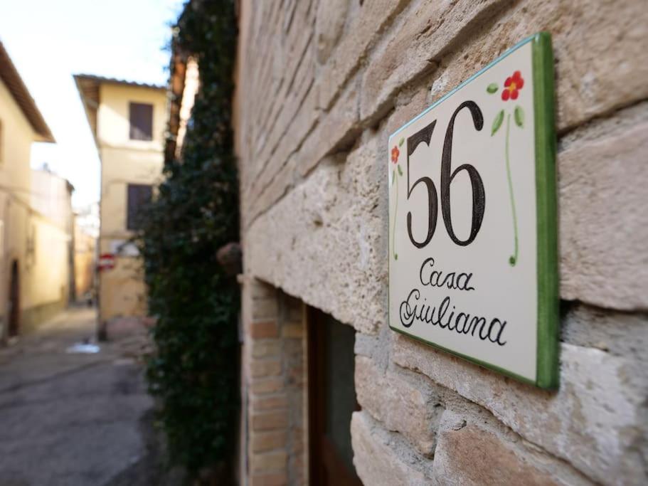 een bord aan de zijkant van een bakstenen gebouw bij City Center “Casa Giuliana” in Perugia