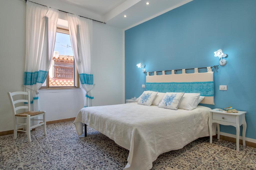 a blue bedroom with a bed and a window at Casa Vacanze San Michele in Alghero