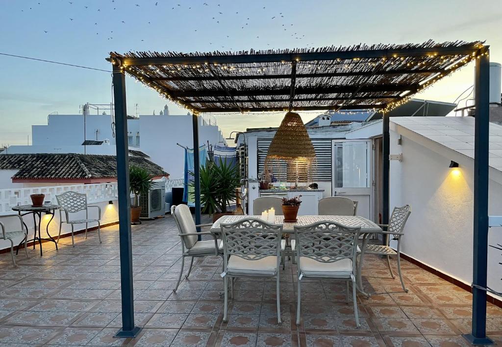 un patio con mesa y sillas en la azotea en Holiday Apartment Casa Granaas, en Mijas