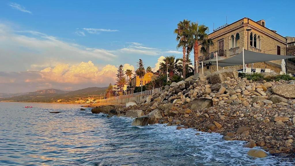 una casa sulla riva di un corpo d'acqua di L’attico del capitano: loft con terazza sul mare a Marina di Caronia