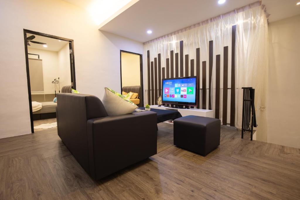 a living room with a couch and a television at Casa Le Rock in Kuah