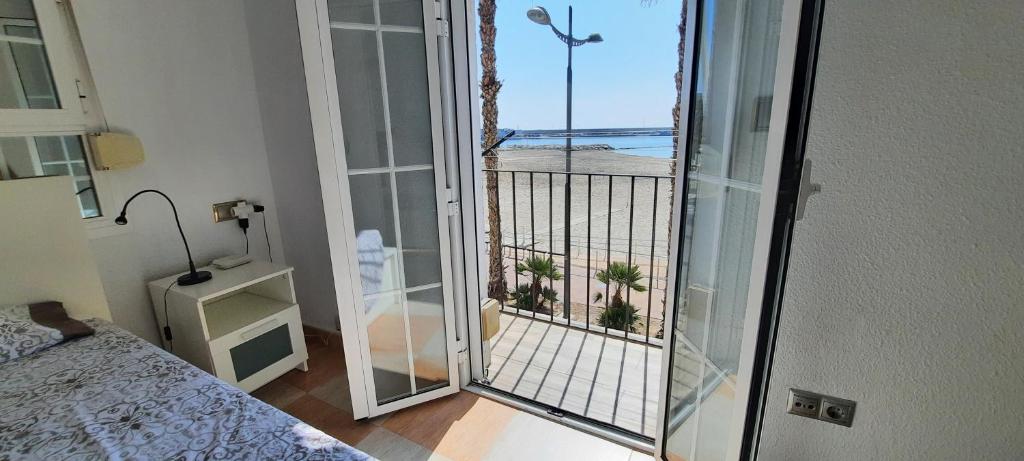 a bedroom with a balcony with a view of the ocean at POS, Apartamento pesquero en primera linea in Era de Soler