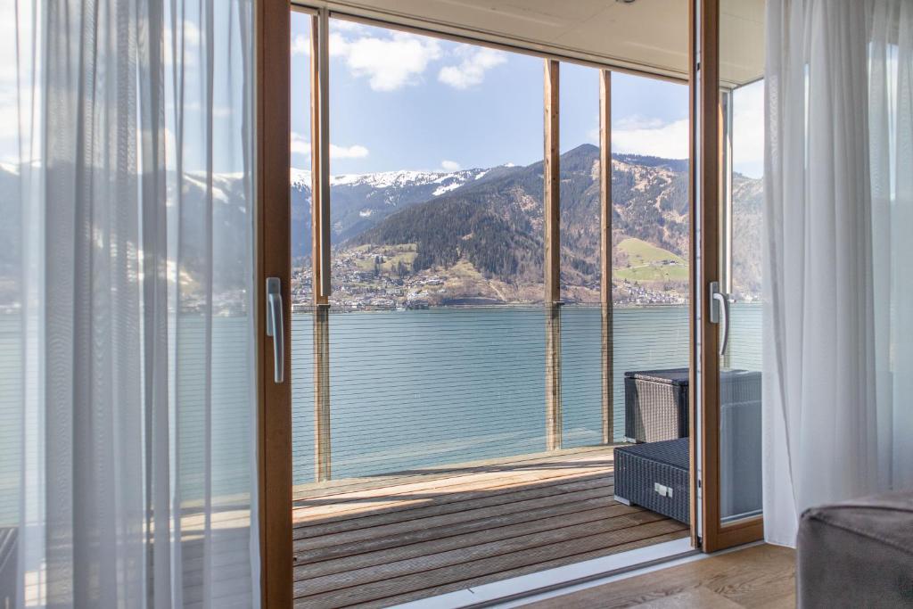 a room with a balcony with a view of the water at Residence Bellevue by Alpin Rentals in Zell am See