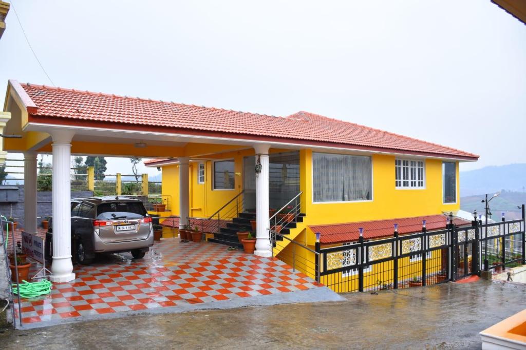 a yellow house with a car parked in front of it at Glen Premium Villa By LexStays in Ooty