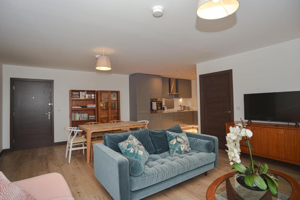 ein Wohnzimmer mit einem blauen Sofa und einem Tisch in der Unterkunft Seaview Point, Superb 2- bedroom flat, 12th Floor in Southend-on-Sea