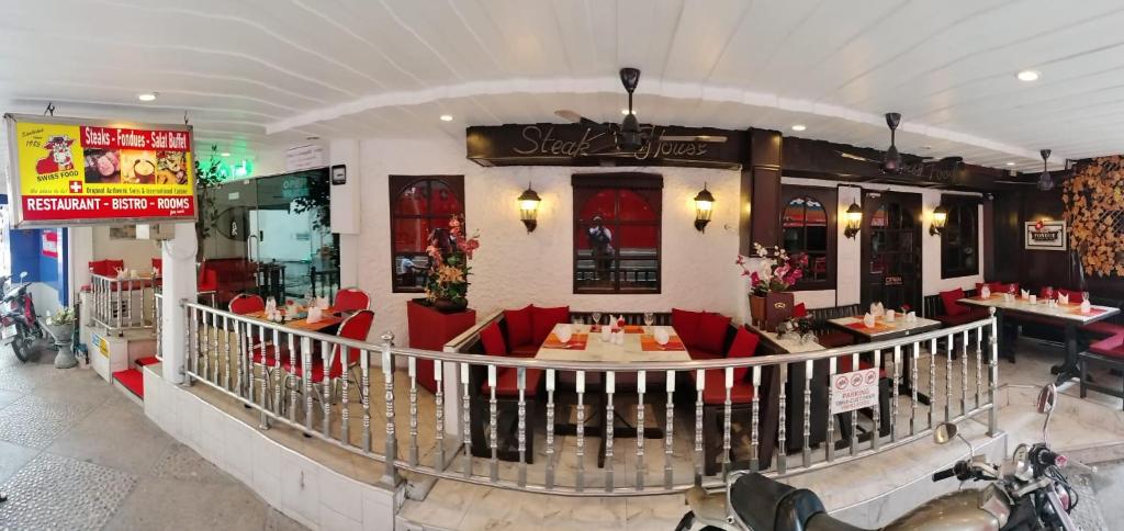 a restaurant with red chairs and tables in a building at Swiss Food Restaurant and room for rent in Pattaya South