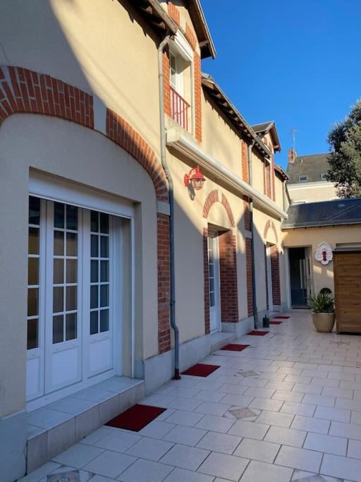 un bâtiment avec une porte blanche et une passerelle dans l'établissement LES JARDINS DE MA-MANS Maison cosy centre Le Mans PARKING privé gratuit, au Mans