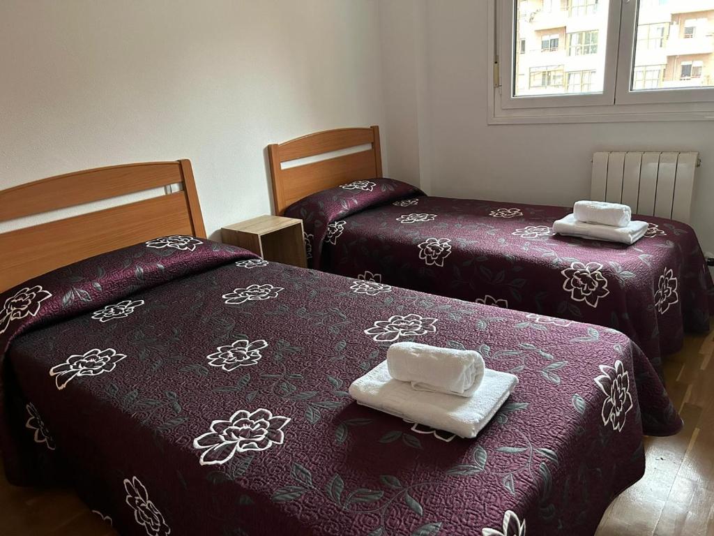 duas camas com toalhas num quarto em H. LAVID em Briviesca