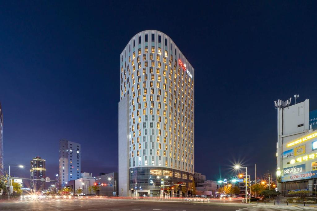 a tall building in a city at night at Staz Hotel Ulsan in Ulsan