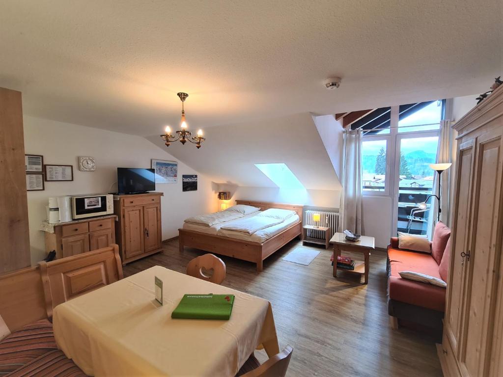 um quarto com uma cama, uma mesa e um sofá em Montana Haus, Fewo B20 em Oberstdorf