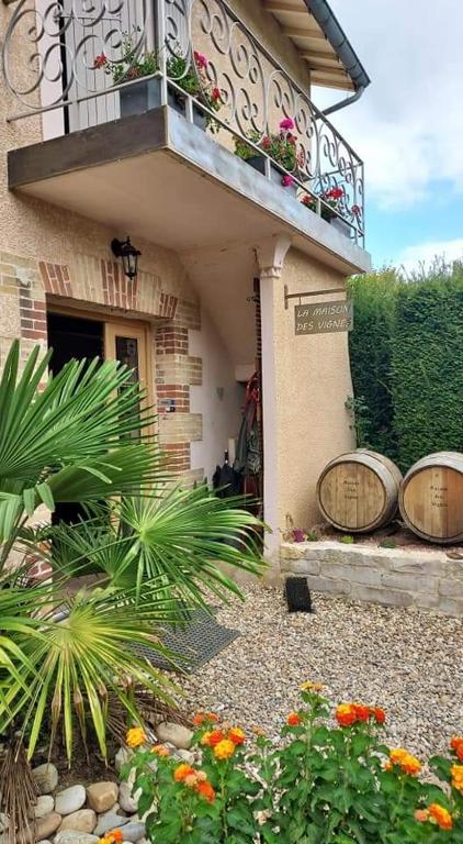 un bâtiment avec un balcon fleuri dans l'établissement La Maison des Vignes, à Charentay