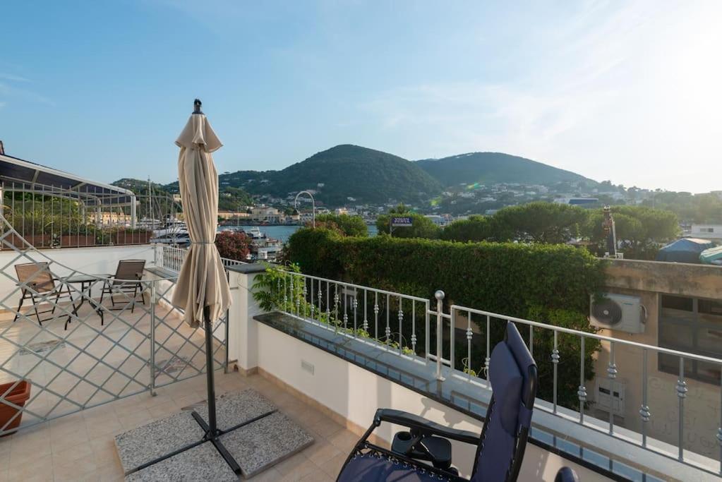 - un balcon avec un parasol, une table et des chaises dans l'établissement Ischia Riva House Apartament, à Ischia