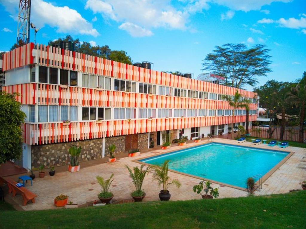 a building with a swimming pool in front of a building at Hotel Boulevard in Nairobi