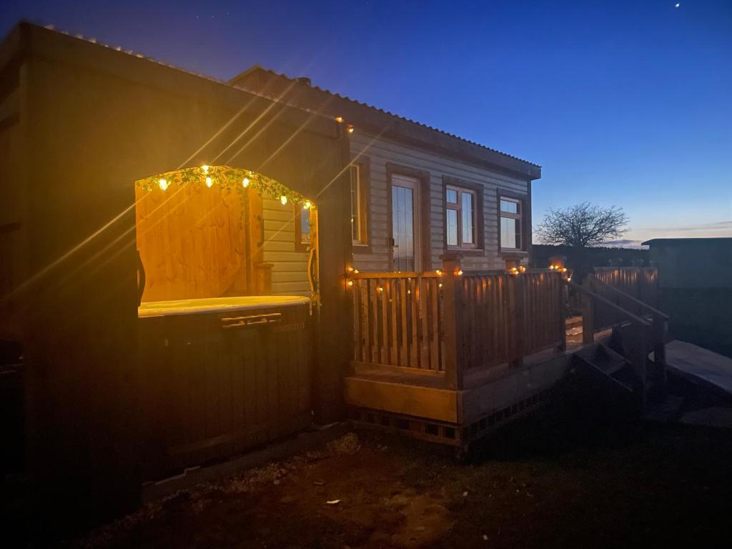 Una casa con luces en el costado. en Keepers Shepherd hut with Hot Tub en Whitby