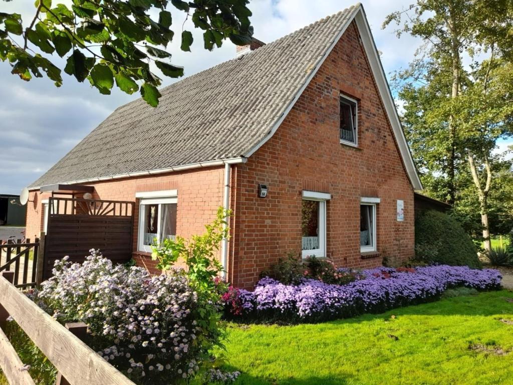 a brick house with flowers in the yard at Ferienhof-Meyer in Wingst