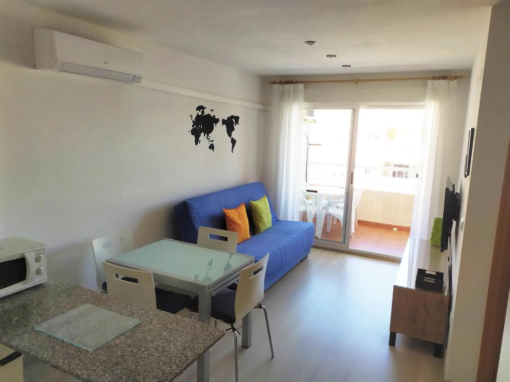 ein Wohnzimmer mit einem blauen Sofa und einem Tisch in der Unterkunft El Racó in Canet d'en Berenguer