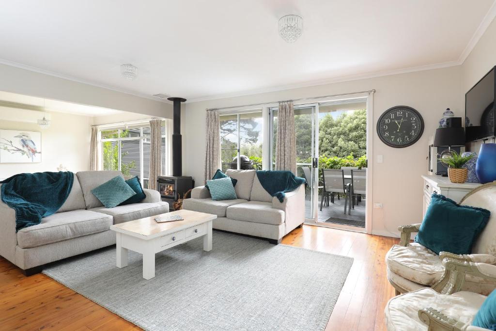 a living room with two couches and a table at Camellia Cottage in Wentworth Falls