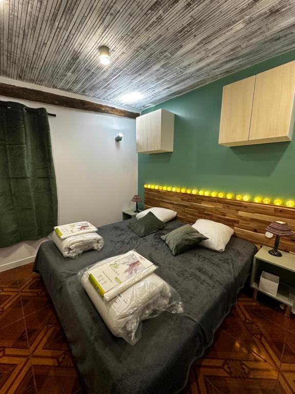 - une chambre avec 2 lits et un mur vert dans l'établissement LE WÜRM, 