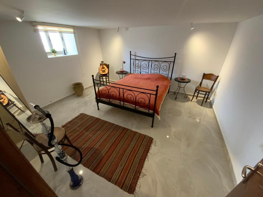 a bedroom with a bed and chairs and a window at Bethlehem-the-Wall Apartment in Bethlehem