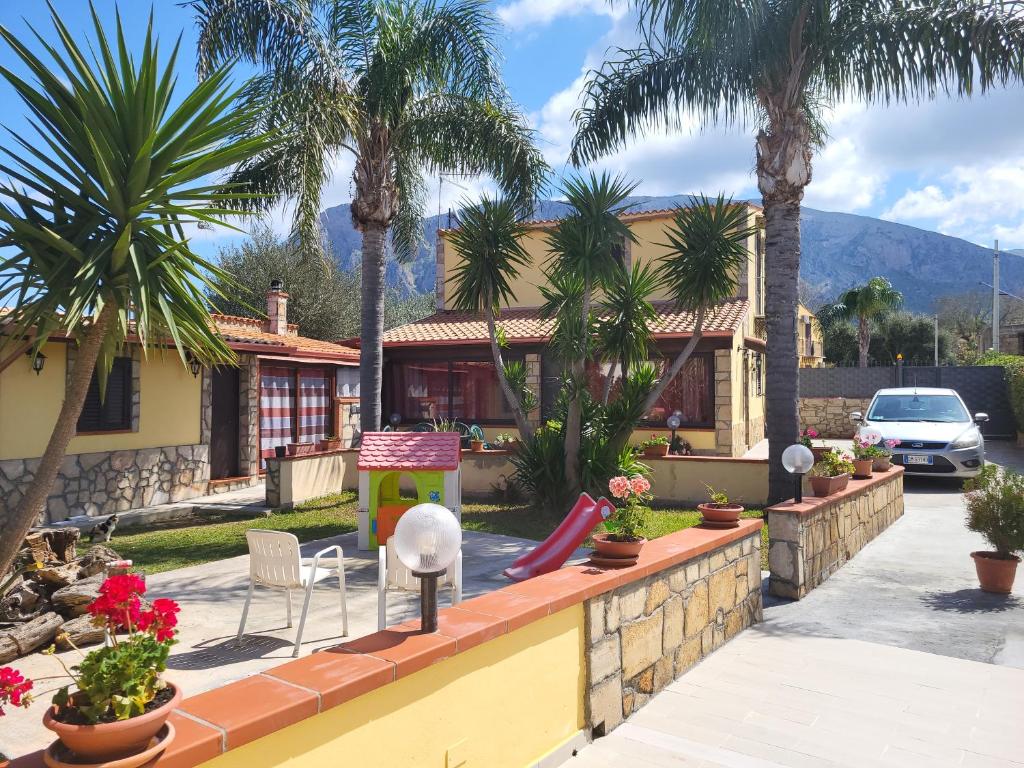 a house with palm trees and a slide at Villa enza in Cinisi