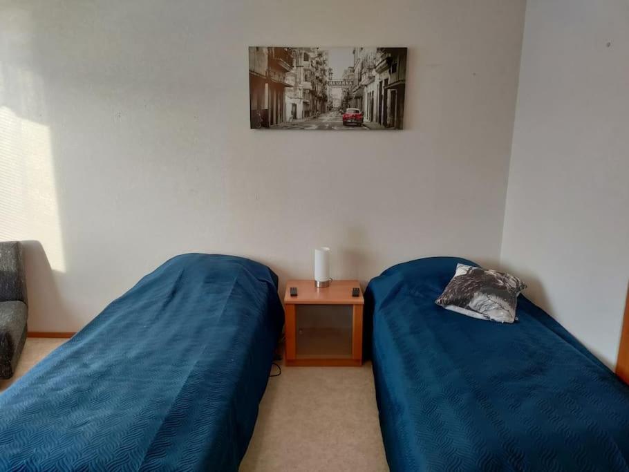黑諾拉的住宿－Toimiva kodikas yksiö，一间卧室配有两张蓝色的床和一张桌子