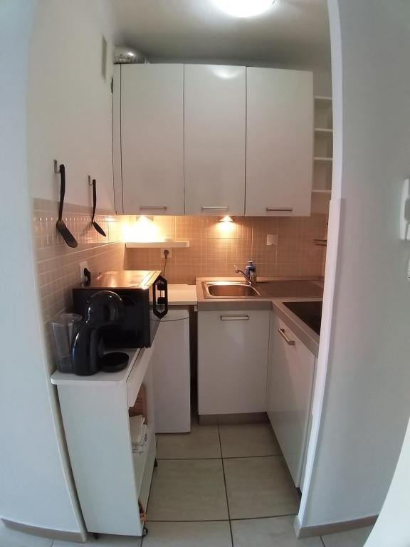 a small kitchen with white cabinets and a sink at Gabriella in Menton