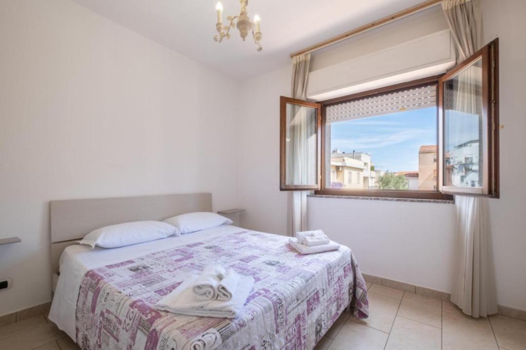 Un dormitorio con una cama y una ventana grande. en Dimoras Ampio Appartamento Centrocittà, en Olbia