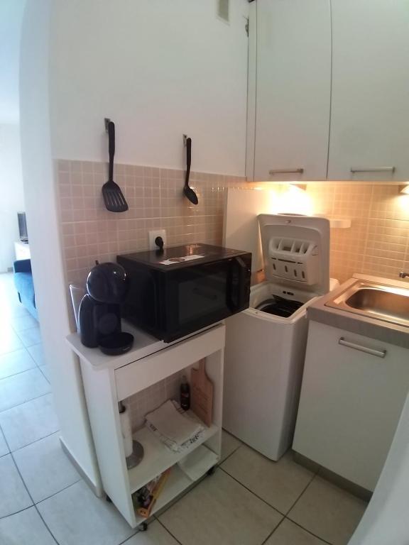 a small kitchen with a sink and a microwave at Gabriella in Menton
