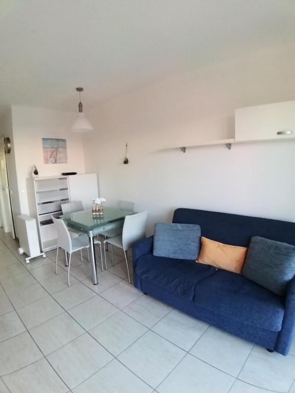 a living room with a blue couch and a table at Gabriella in Menton