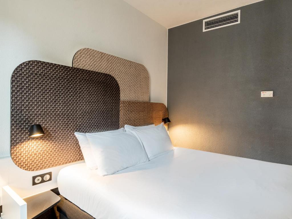 - une chambre avec un lit blanc et une tête de lit dans l'établissement B&B HOTEL Marseille Prado Parc des Expositions, à Marseille