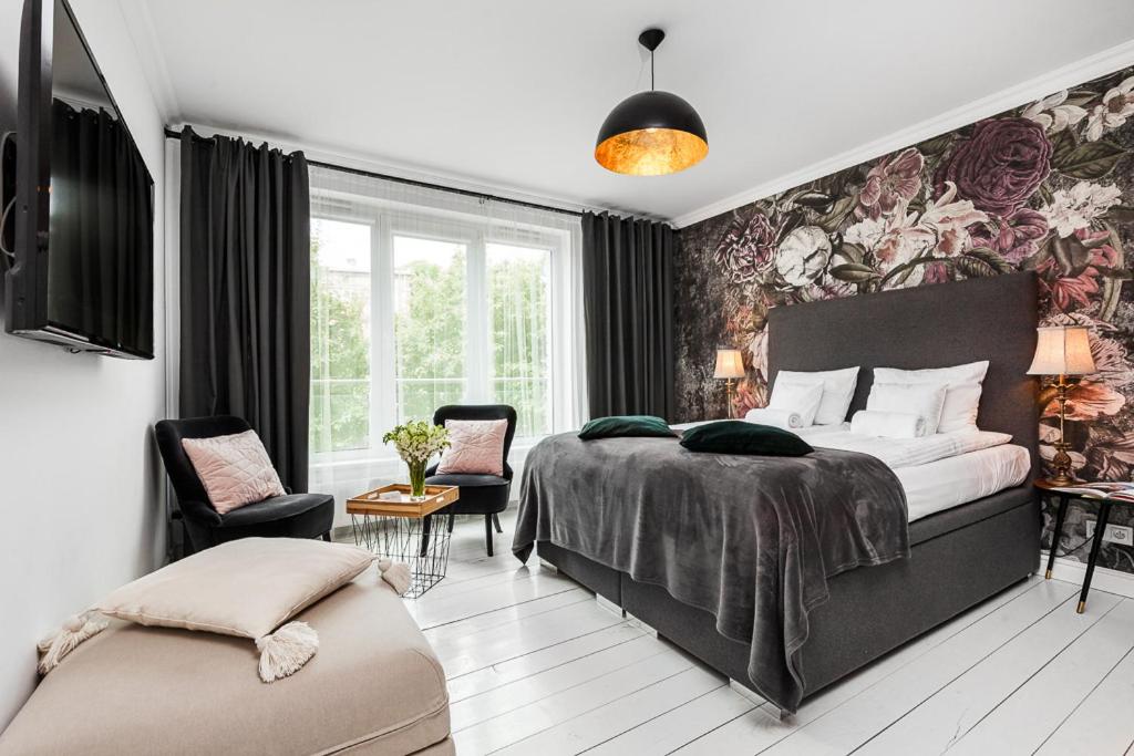 グダニスクにあるHappy Stay Tartaczna Residence Iの花柄の壁紙を用いたベッドルーム1室(大型ベッド1台付)