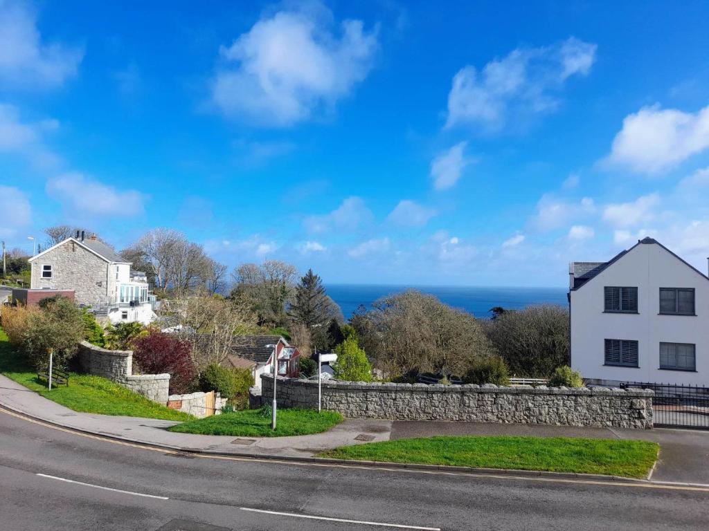 a house and a road with the ocean in the background at Thurlestone House in St Ives